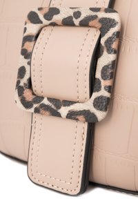 Borsa a mano in ecopelle beige con dettagli, che presenta una fibbia con stampa leopardata, cuciture a contrasto e uno sfondo con una texture a coccodrillo.