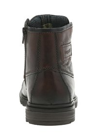 Bottine en cuir marron avec des accents cousus, fermeture éclair apparente, et doublure texturée visible par le haut. Semelle en caoutchouc avec un léger talon.