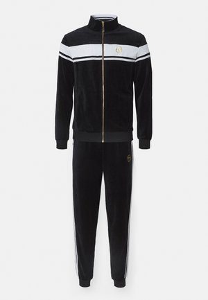 Schwarzer Velours-Trainingsanzug mit einem weißen und schwarzen Streifenmuster, Reißverschlussjacke und elastischen Bundhosen; mit goldenen Logo-Akzenten.