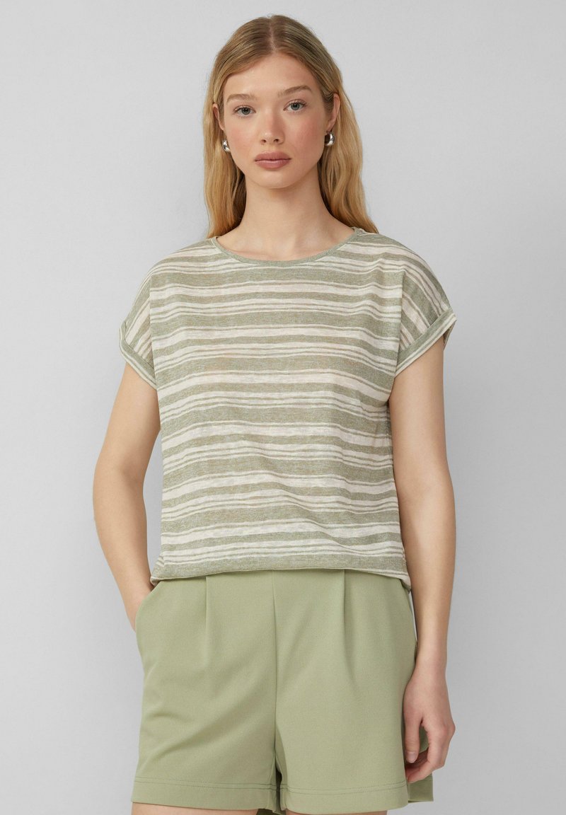 Jasnozielona, w paski, krótka koszulka z rękawem, wykonana z miękkiego, teksturowanego materiału. Posiada okrągły dekolt i podwinięte mankiety. W połączeniu z jasnozielonymi szortami.