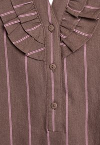 Brown fabric blouse with vertical pink stripes, featuring a ruffled collar and five brown buttons along the front for closure.