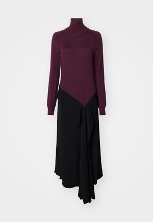 Long-sleeve, turtleneck dress in burgundy with an asymmetrical black skirt section, featuring soft textures and layered fabric design.
