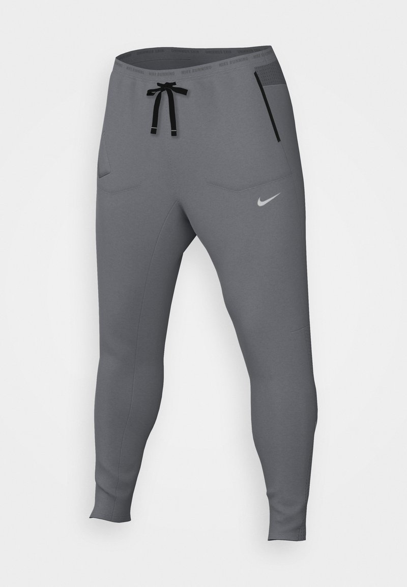 Sive trkaće hlače s suženim dizajnom, dva džepa, crnu vezicu i suptilan Nike logo na donjem prednjem dijelu. Glatka tekstura tkanine.