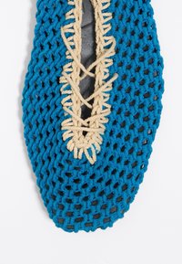 Gebreid blauw textiel schoen met een zwarte zool, voorzien van beige koorden voor de vetersluiting en een mesh ontwerp, wat zorgt voor ademend vermogen en een uniek patroon.