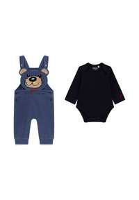 Jeanslatzhosen mit Bärenkopf-Design und roten Schriftzügen, kombiniert mit einem schwarzen Langarm-Body, der an der Unterseite Druckknöpfe hat.
