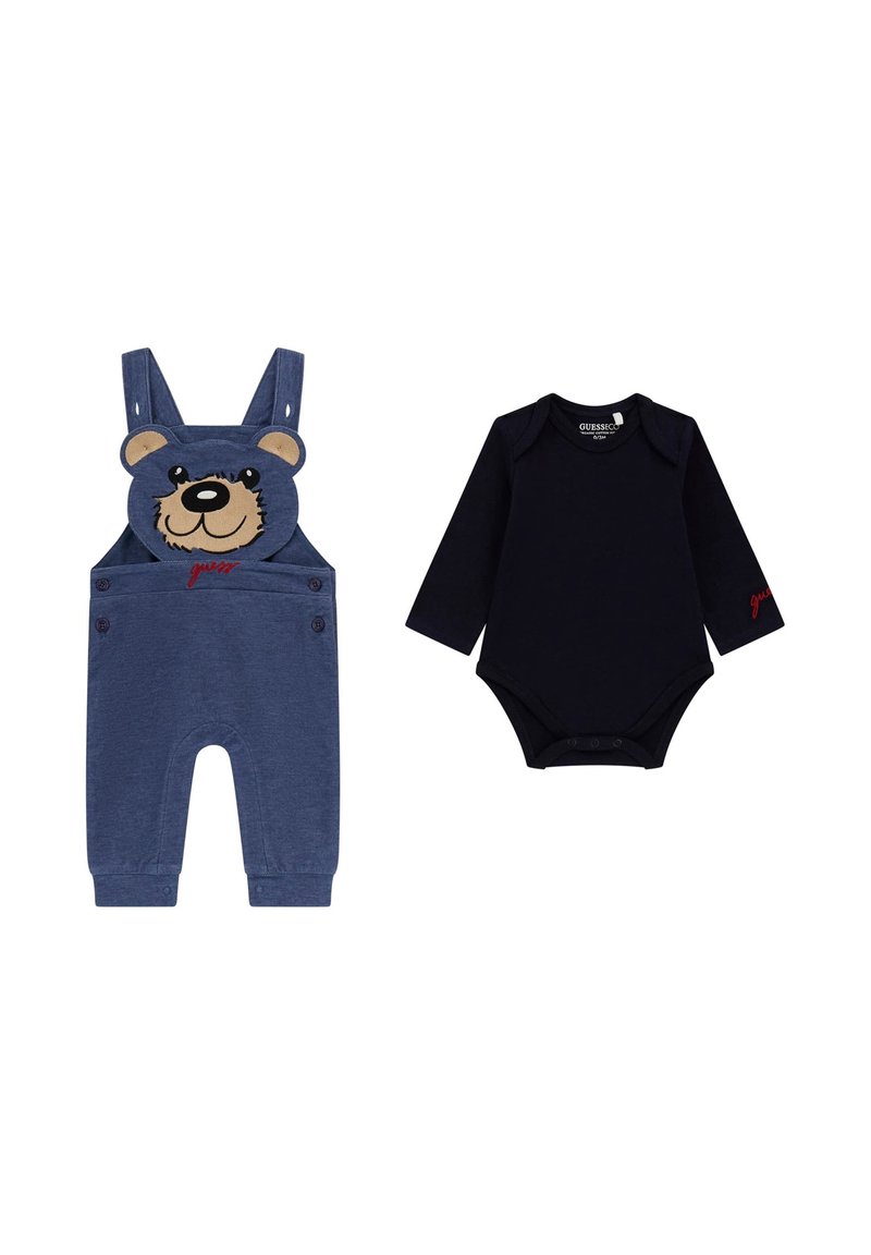 Jeanslatzhosen mit Bärenkopf-Design und roten Schriftzügen, kombiniert mit einem schwarzen Langarm-Body, der an der Unterseite Druckknöpfe hat.