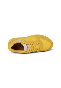 Scarpa da atletica gialla con tomaia texture, chiusura con lacci e soletta in sughero. Presenta una suola in gomma liscia e un logo discreto.