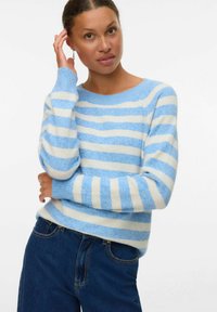Lichtblauw en crèmekleurig gestreept trui met een ronde hals en ribgebreide manchetten. Gemaakt van zacht, textuur materiaal. Gecombineerd met donkerdenim jeans.