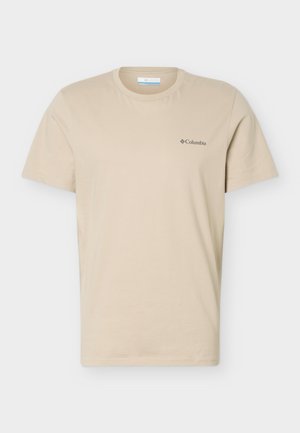 Μπεζ κοντομάνικο t-shirt με στρογγυλή λαιμόκοψη και μικρό μαύρο λογότυπο Columbia στο αριστερό στήθος, εμφανίζεται σε απλό ανοιχτό γκρι φόντο.
