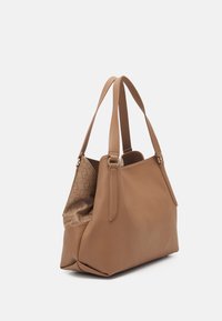 Tan lædertaske med tekstureret ydre, dobbelte skulderstropper og mønstret stofforing. Har et rummeligt hovedrum.