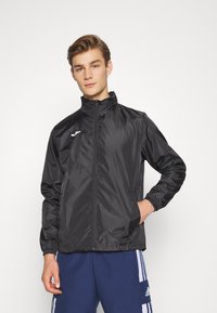 Black windbreaker jacket with a high collar, full front zipper, elastic cuffs, and a subtle white logo on the left chest.