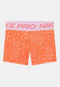 Nike Pro orange Shorts mit einem pinken Bund. Der Stoff hat ein wei�ßes Punktmuster und ein kleines pinkes Logo in der unteren rechten Ecke.