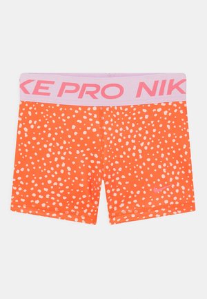 Nike Pro oranžové šortky s růžovým pasem. Materiál má bílou puntíkovou vzor a malé růžové logo v pravém dolním rohu.