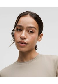 Beige cotton t-shirt with a round neckline and short sleeves, featuring smooth texture and minimal stitching detail.