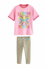 Camiseta rosa de manga corta con un gráfico colorido de mariposa y flores, combinada con leggings elásticos que presentan un patrón de olas de arcoíris.
