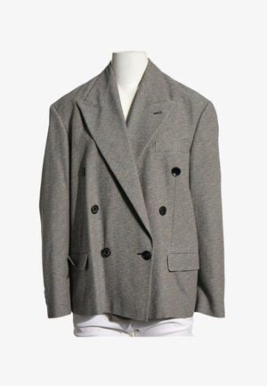 Blazer gris de doble botonadura con botones negros exhibido en un torso de maniquí blanco sobre un fondo blanco.