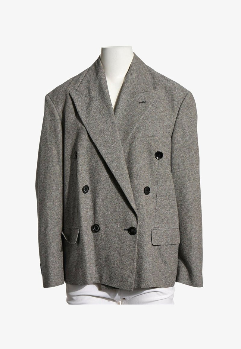Blazer gris croisé avec boutons noirs présenté sur un buste de mannequin blanc sur fond blanc.