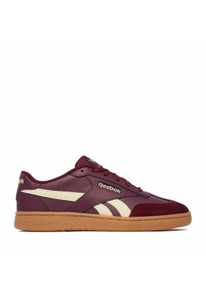 Niskie buty sportowe Reebok w ciemnym bordowym kolorze z kremowymi paskami po bokach i gumową podeszwą, widziane od zewnętrznej strony.