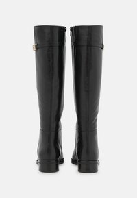 Botas de cuero negro hasta la rodilla con un acabado suave, que cuentan con una cremallera lateral, detalles de hebilla y un tacón bajo y apilado.