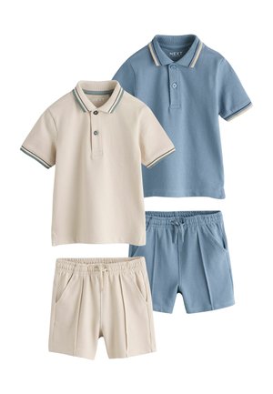 Dwie koszulki polo dla dzieci i dopasowane szorty z elastycznym pasem, jedna para w beżowym kolorze, druga w jasnoniebieskim, obie z paskami na kołnierzyku i krawędziach rękawów.