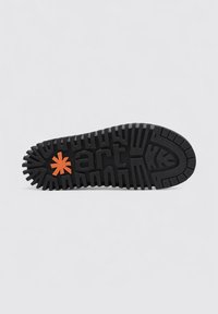 Suela de zapato de goma negra con un patrón de textura, que presenta un logo de estrella naranja y la palabra "art" en letras en relieve de color negro.