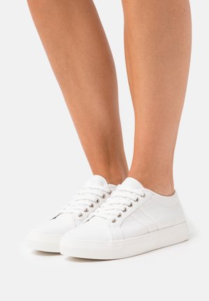 Vita kanvas sneakers med runda tår, sex ögla och gummisulor. Ren design och minimala accenter, lämpliga för avslappnad användning.