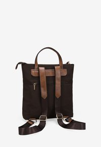 Mochila de tela negra con acentos de cuero marrón, doble asa en la parte superior y correas ajustables marrones, que cuenta con un bolsillo frontal con cremallera.