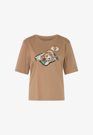 Brown cotton t-shirt featuring a graphic of a dog on a patterned blanket, with a thought bubble containing a tea cup illustration.