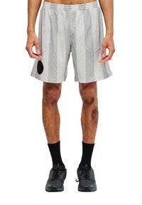 Ljusgrå idrottsshorts med ett geometriskt mönster, elastisk midja, sidofickor och en svart logotyp-patch på vänster lår. Svarta strumpor och skor.