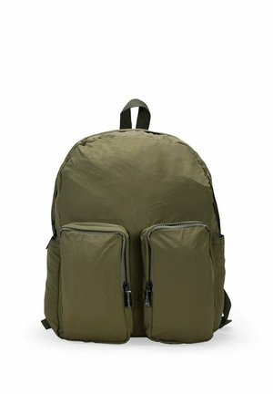Mochila de tela verde oliva con forma redondeada, dos bolsillos frontales con cremallera y una asa en la parte superior para llevar. Material texturizado.