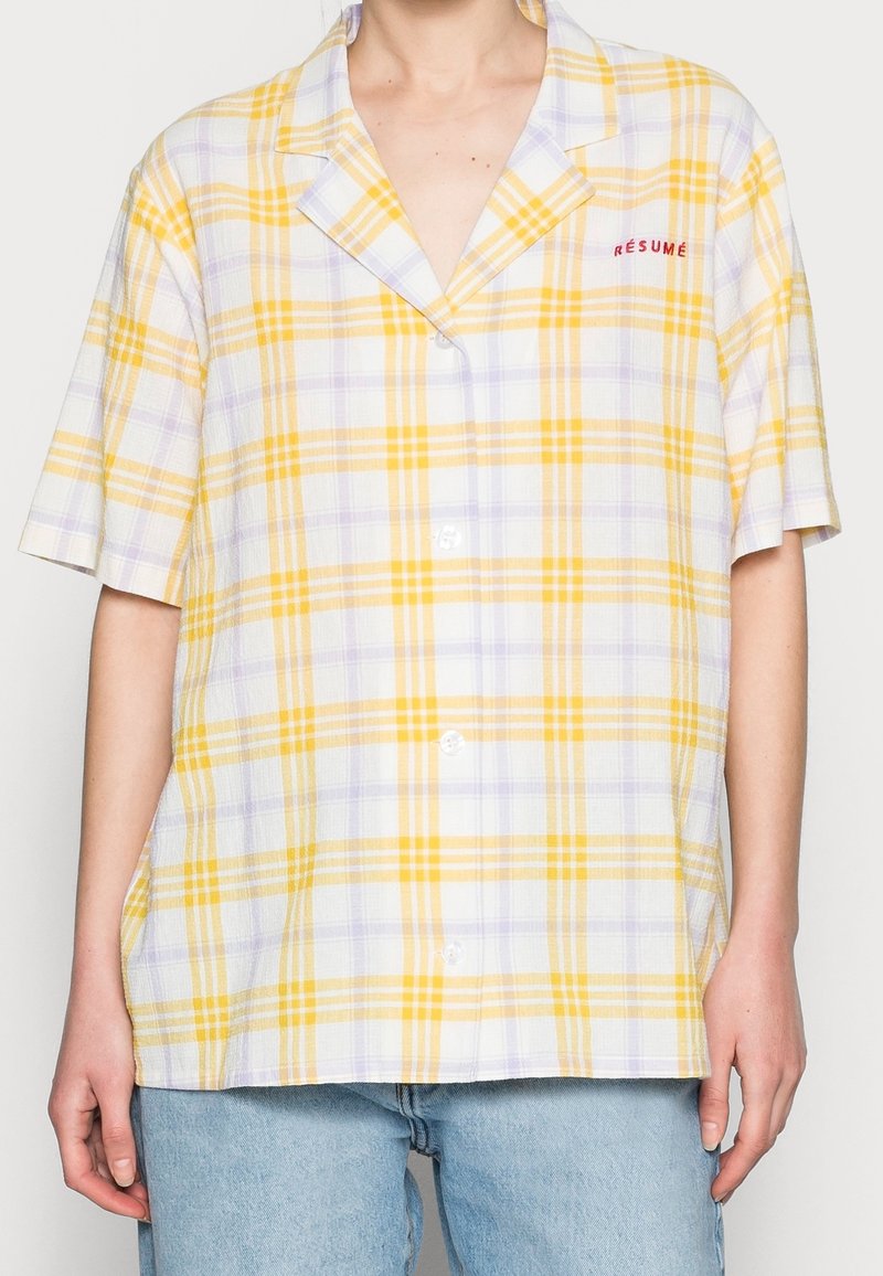 Kortärmad, knäppskjorta med randigt mönster i gult och lavendel, med krage och ordet "RÉSUMÉ" broderat i rött.