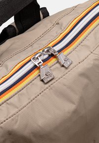 Borsa beige con zip, dotata di due zip argentate e strisce multicolori (arancione, giallo, blu, bianco) lungo la parte superiore. Finitura in tessuto testurizzato.