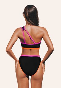 Set di bikini nero con accenti rosa e arancione. Il top presenta spalline regolabili e il pantalone è a vita alta con bordi a contrasto.