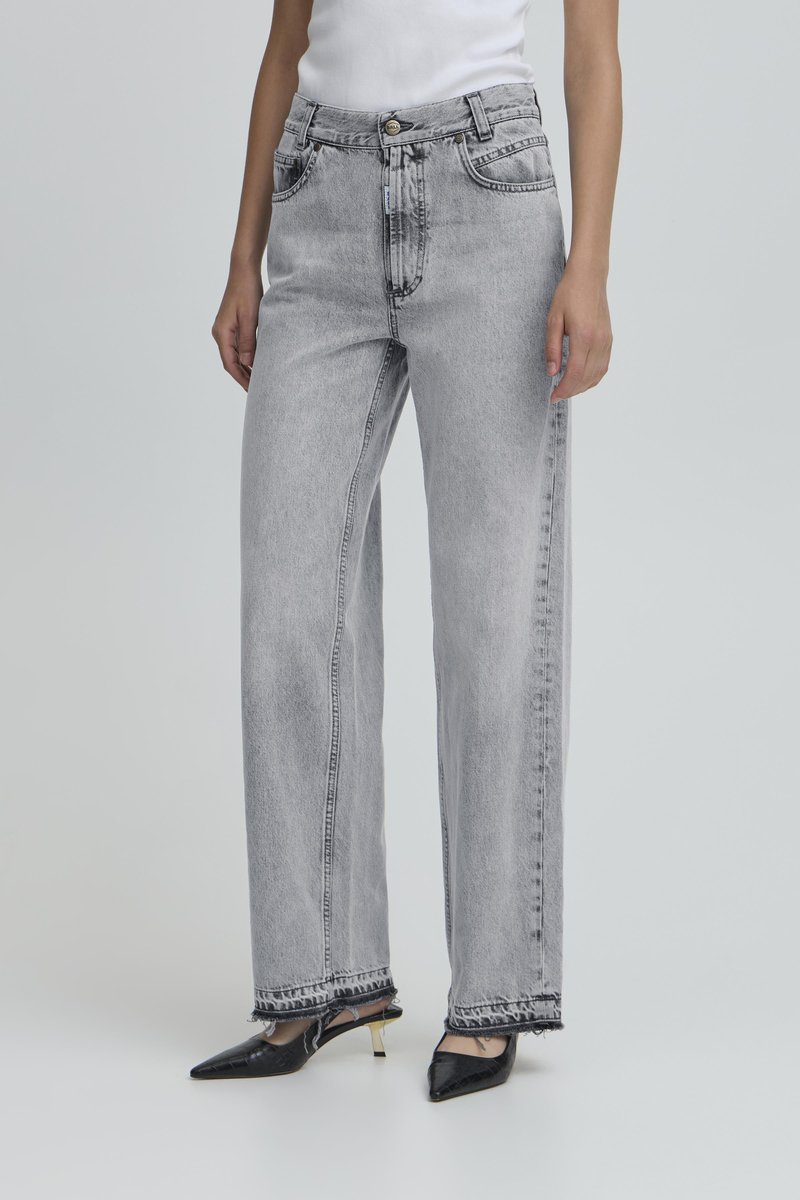 Grijze, hooggetailleerde wijde jeans met vijf zakken, zichtbare stiksels en rafelige zoom, gecombineerd met zwarte puntige hakken.