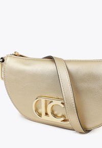 Borsa a tracolla metallica dorata con un design curvo e un logo dorato in evidenza. Presenta una tracolla per un facile trasporto.