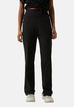 Black athletic pants with a high waistband and relaxed fit. Smooth fabric, subtle sheen, side pockets, and elastic detailing at the hem.
