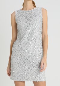 Robe sans manches argentée présentant un design texturé en sequins avec un motif en losanges. Elle a un décolleté rond et une silhouette ajustée.