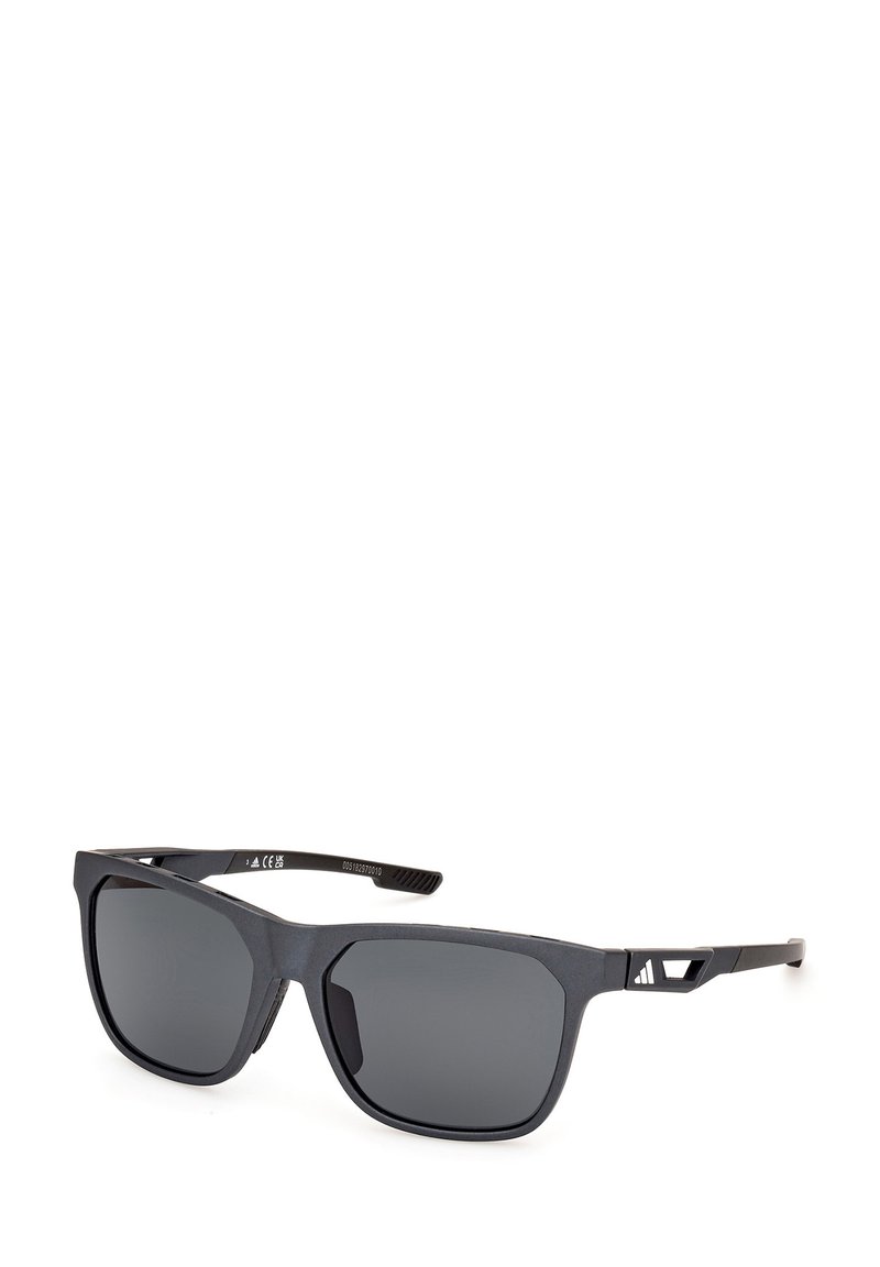 Black sunglasses with a rectangular shape. Frame features a matte texture and smooth gray lenses. Accented by a distinctive cutout on the arm.