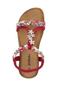 Röd sandal med t-stropp och blommönstrade flätade remmar samt silverfärgade blomdekorationer. Mjuk, texturerad fotbädd märkt "palado." Flexibel gummisula.