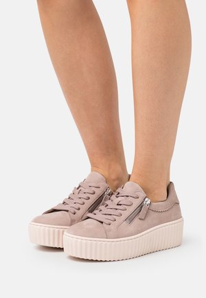 Pink suede platform sneakers with a textured light-colored sole, featuring side zippers and round laces for secure fit. Smooth surface, low-top design.