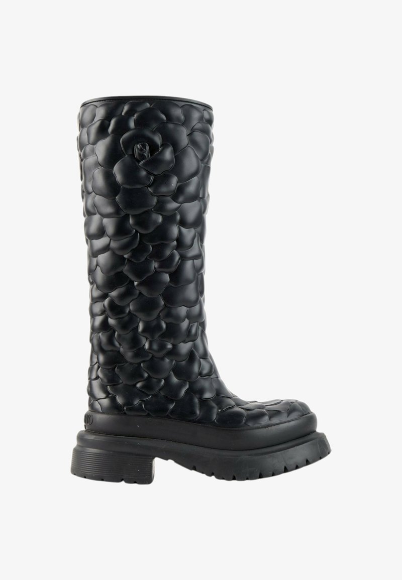 Botte noire mi-mollet avec semelle épaisse et texture en relief 3D de pétales floraux couvrant toute la surface de la botte.