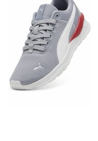 Šedé síťované sportovní tenisky s bílou podrážkou, s šedými tkaničkami a červeným akcentem na patě. Texturovaný svršek pro prodyšnost.