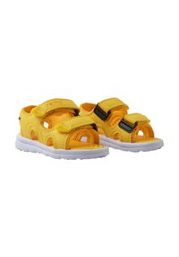 Gule sandaler med myk overdel, som har doble justerbare stropper med svarte spenner, og en hvit gummisåle. Teksturert oransje innersåle.