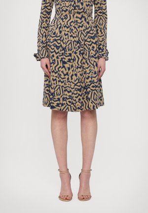 Rochie cu mânecă lungă, având un model geometric în nuanțe de bleumarin și bej, cu talie ajustată și fustă largă. Complementată cu sandale cu toc nude.