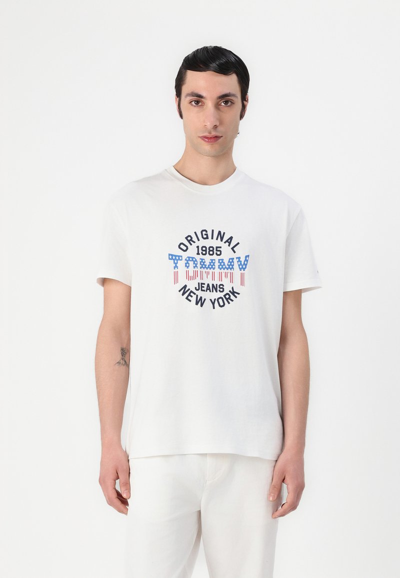 Fehér pamut póló kerek nyakkal, elöl kék és piros nyomott logóval "ORIGINAL 1985 TOMMY JEANS NEW YORK".