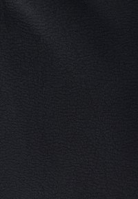 Mustast kangast, millel on pehme ja tekstuuriga pind, mis kuvab ühtlast mustrit. Materjal näib kerge ja paindlik.