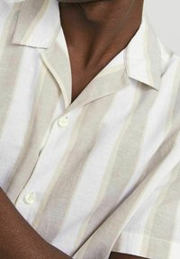 Korte mouw shirt van lichtgewicht stof, met verticale beige en witte strepen, een kraag en een knoopsluiting.