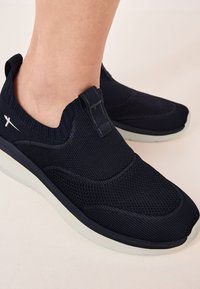 Sneakers slip-on blu navy con superiore in rete testurizzata, colletto imbottito e suola in gomma bianca. Caratterizzati da un anello in tessuto per indossarli facilmente.