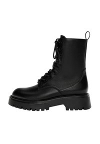 Botte de cheville noire à lacets en cuir synthétique, dotée d'une semelle épaisse, d'une languette et de détails de couture prononcés.