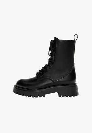 Schwarze Schnürstiefelette aus synthetischem Leder, mit einer stabilen Sohle, einer Zuglasche und ausgeprägten Nähdetails.